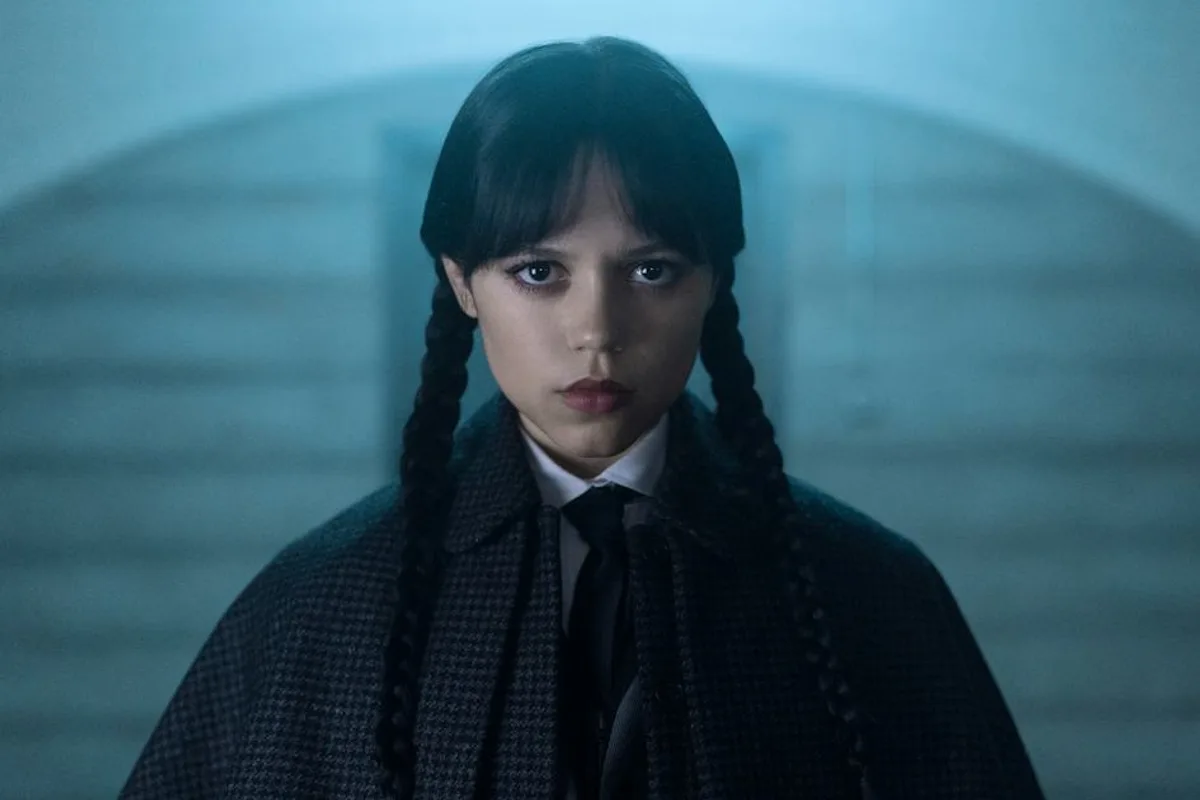 Jenna Ortega dans le rôle de Wednesday Addams, portant les tresses et l'uniforme sombres caractéristiques du personnage